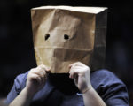 A fan with a paper bag over his head watches during the fourth quarter of an NBA basketball game between the New Jersey Nets and the Miami Heat on Monday, March 22, 2010, in East Rutherford, N.J. The Nets have a 7-63 record as the Heat defeated the Nets 99-89. (AP Photo/Bill Kostroun)